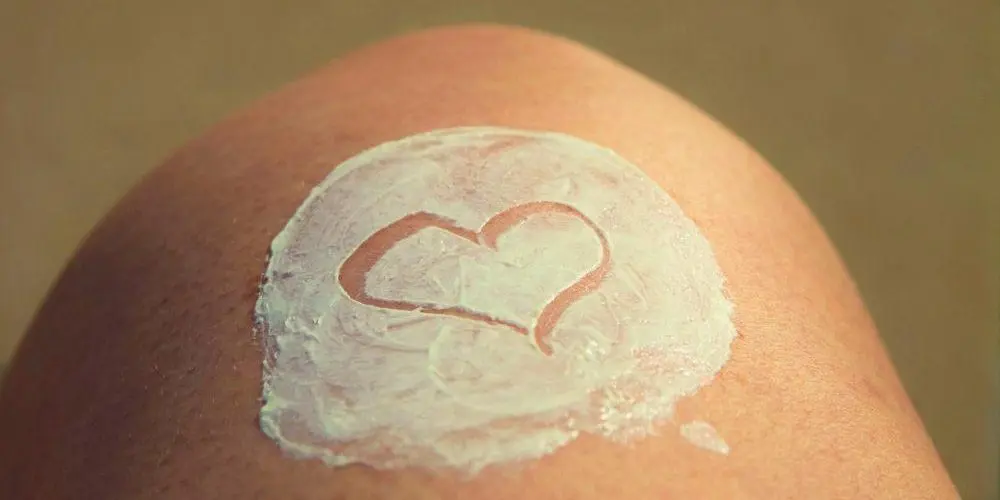 crema spalmata a forma di cuore sul ginocchio