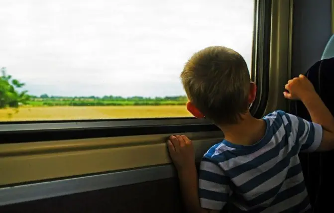 bambino in treno guarda fuori dal finestrino
