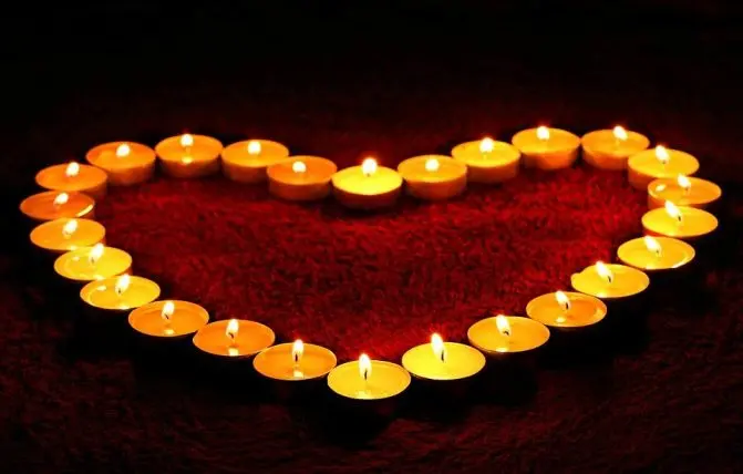 candele accese disposte a forma di cuore