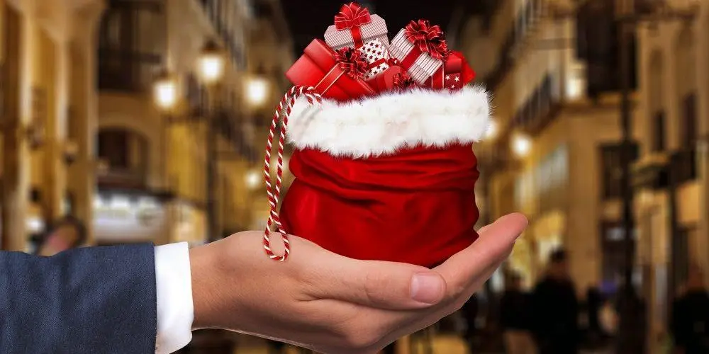 uomo tiene in mano un sacco con regali di natale