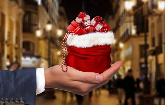 uomo tiene in mano un sacco con regali di natale