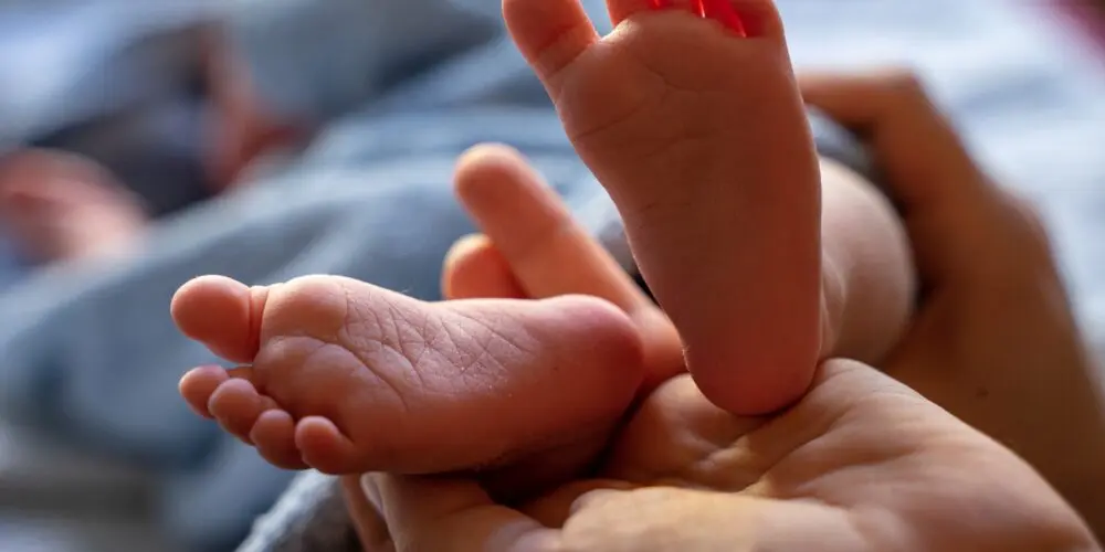 Piedi di neonato in cui si fa lo screening metabolico