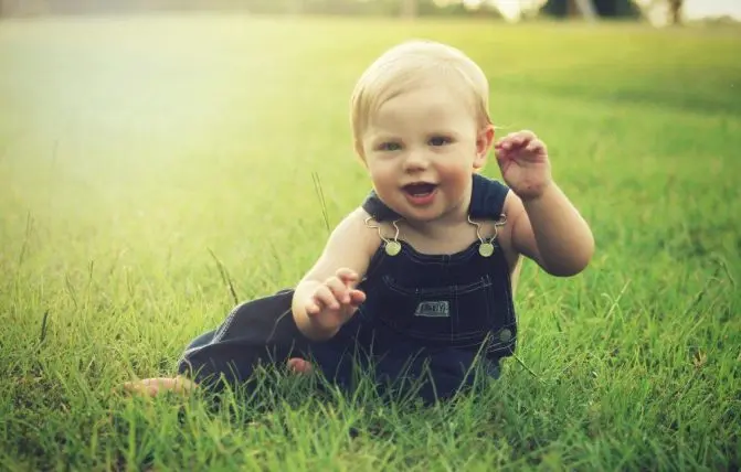 bambino di un anno felice gioca nel prato