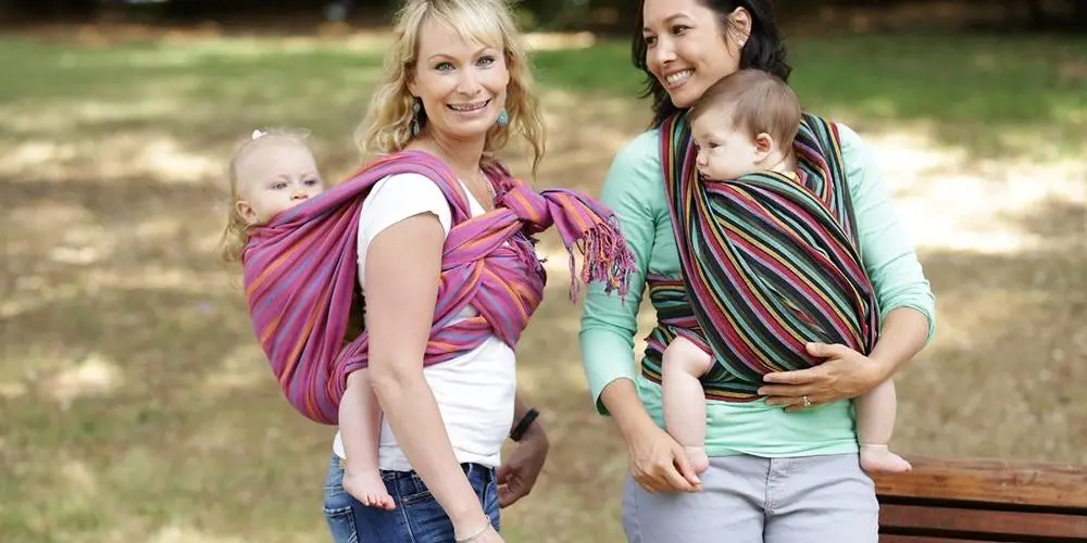 mamme portano a spasso bambini nella fascia