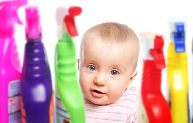 bambino in mezzo a detersivi per la casa