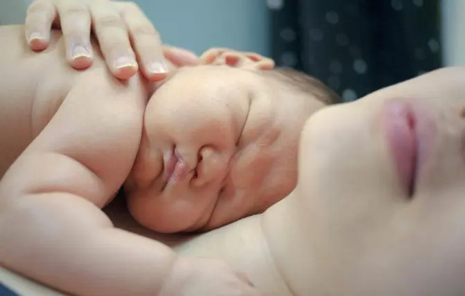 neonato dorme in braccio alla mamma