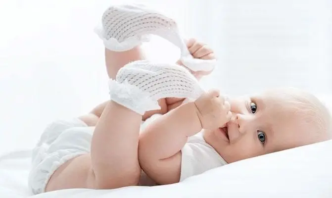 neonato si tira via le calze bianche