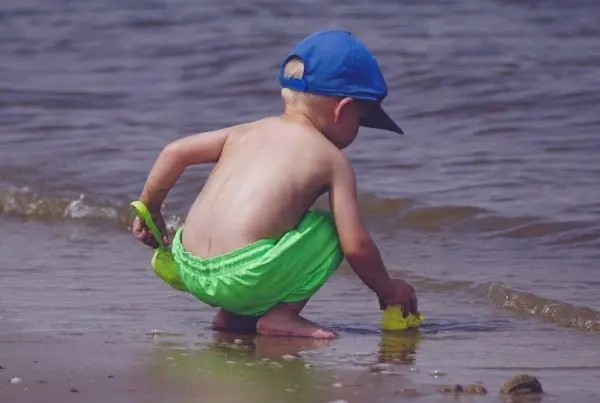 bambino gioca con la sabbia in riva al mare