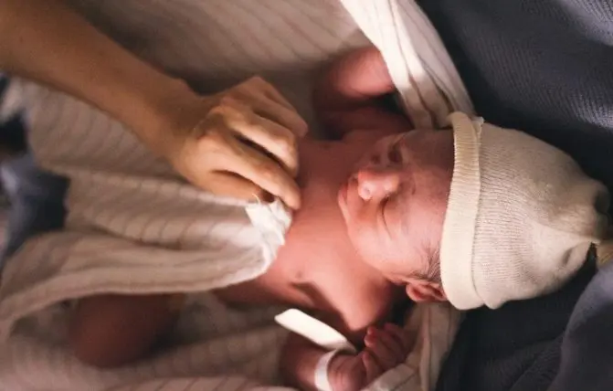 mamma copre neonato di un mese con una coperta