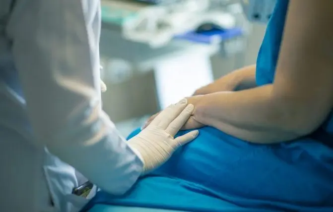 medico con guanto di silicone tocca la mano della paziente