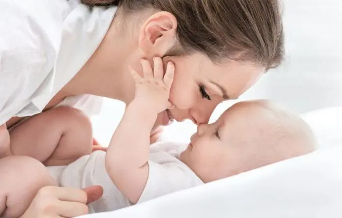 donna tocca con il proprio naso la punta del naso del proprio bambino