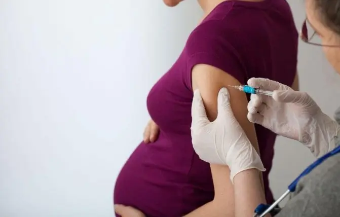 medico effettua vaccino antinfluenzale a donna in gravidanza