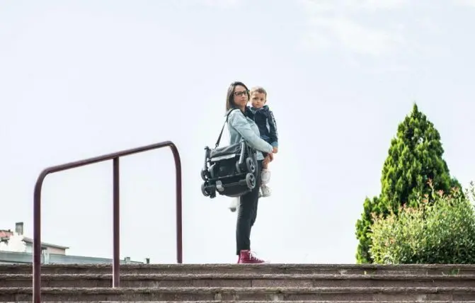 Donna con bambino in braccio e passeggino ultraleggero Piuma