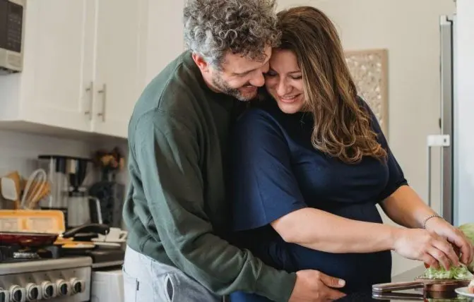uomo abbraccia donna incinta