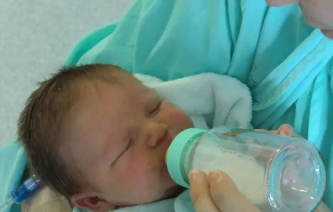 neonato beve dal biberon