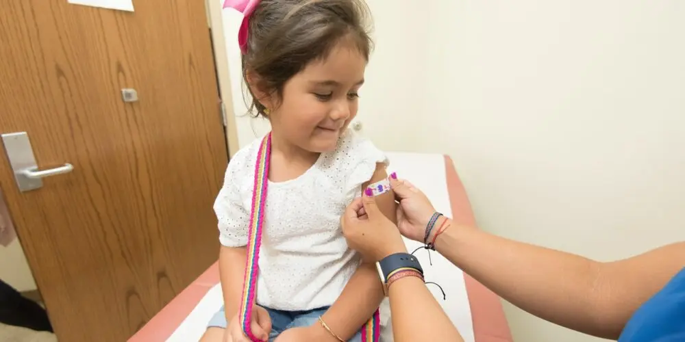 bambina con un cerotto dopo il vaccino