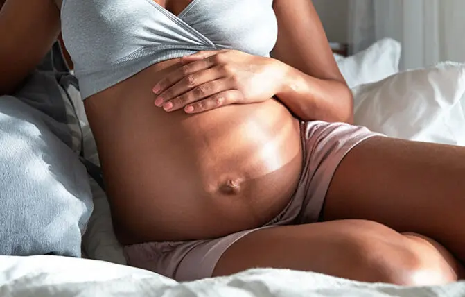 donna incinta accarezza il pancione per prevenire smagliature