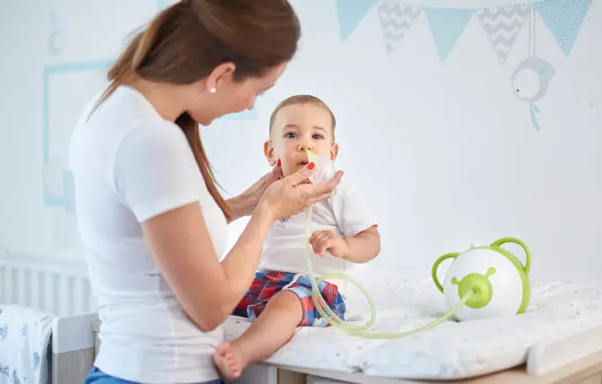 Donna aspira muco per raffreddore nei bambini